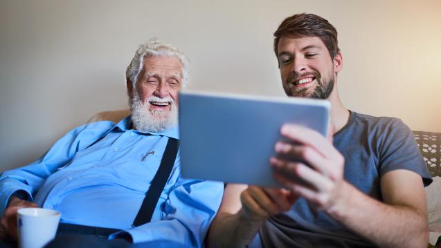 older and young men looking at tablet